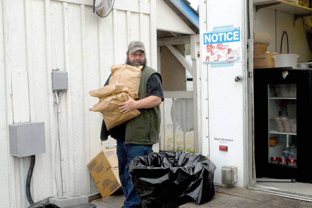 Corner Caboose co-owner Howard Reynolds carries supplies from a food preperation and storage area to the eaterys kitchen. (Keith Thorpe/Peninsula Daily News)