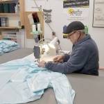 Jeff Johnson, canvas guru of Sea Marine, works on sewing together a hospital gown in the Sea Marine store. (Sea Marine)