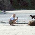 Caitlin Granade, left, and Gabrielle Thetford, both of Poulsbo, take photographs of Mango Salsa, a Boston terrier, on the beach at Salt Creek Recreation Area north of Joyce on Saturday, May 9, 2020. (Keith Thorpe/Peninsula Daily News)