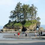 Visitors to the Salt Creek Recreation Area north of Joyce walk along the beach near the parks sea stack along the shore of Freshwater Bay on Saturday, May 9, 2020. The recreation area, part of the Clallam County parks system, is currently open for day-use only with the main portion of the park and adjoining campground remaining closed during the current COVID-19 health emergency. (Keith Thorpe/Peninsula Daily News)