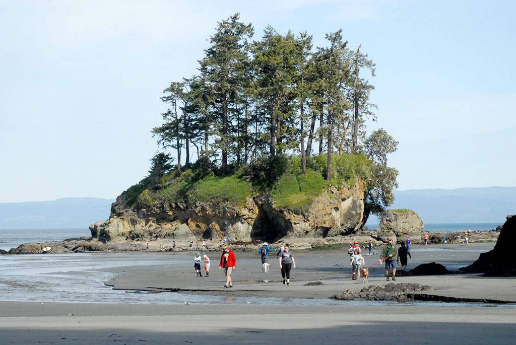Visitors to the Salt Creek Recreation Area north of Joyce walk along the beach near the parks sea stack along the shore of Freshwater Bay on Saturday, May 9, 2020. The recreation area, part of the Clallam County parks system, is currently open for day-use only with the main portion of the park and adjoining campground remaining closed during the current COVID-19 health emergency. (Keith Thorpe/Peninsula Daily News)