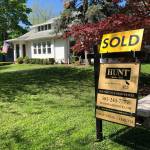 This May 22, 2020, photo shows a sold sign in front of a house in Brighton, N.Y. On Thursday, May 28, long-term U.S. mortgage rates fell this week as the key 30-year home loan marked an all-time low for the third time in the last few months since the coronavirus outbreak took hold. Mortgage buyer Freddie Mac reports that the average rate on the 30-year loan tumbled to 3.15 percent from 3.24 percent last week. (Ted Shaffrey/Associated Press)