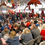 Dungeness Crab & Seafood Festival attendees line up for crab dinners while others dine on a variety of sea food available in the main tent in 2019. (Keith Thorpe/Peninsula Daily News file)