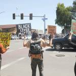 From left, Mackenzie Grinnell, Peter Beeler and Jaiden Dokken hold signs at the corner of Washington Street and Sequim Avenue on Wednesday, protesting racism and the death of George Floyd and other Black men at the hands of police officers. (Michael Dashiell/Olympic Peninsula News Group)
