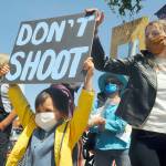 S. Beckett Thomas, 5, holds a Dont shoot sign with mom Courtney Thomas looking on. Courtney organized the protest, saying, Im scared for the world, for my son. This [protest] is the least I can do. (Michael Dashiell/Olympic Peninsula News Group)