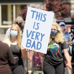 Joei Darminio, left, and Allie Van De Wege join protesters at Washington Street and Sequim Avenue during Wednesdays gathering. (Michael Dashiell/Olympic Peninsula News Group)
