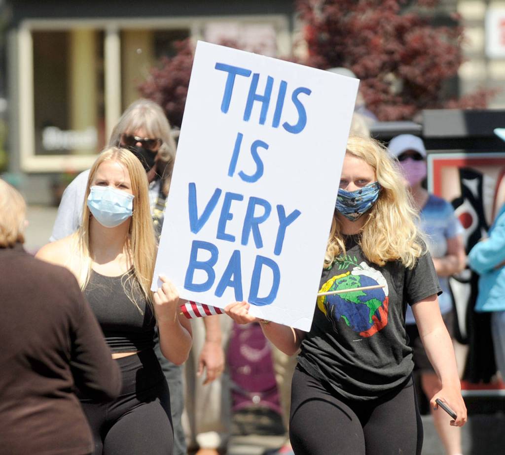 Joei Darminio, left, and Allie Van De Wege join protesters at Washington Street and Sequim Avenue during Wednesdays gathering. (Michael Dashiell/Olympic Peninsula News Group)