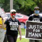 A protester holds a sign that reads Justice for Manny Friday, June 5, 2020, in Tacoma, Wash., during a protest against police brutality and the death of George Floyd, a black man who died after being restrained by Minneapolis police officers on May 25. On Thursday, the mayor of Tacoma called for the firing of police officers involved in the death of Manuel Ellis, who died March 3 while being held down by Tacoma police, after the Pierce County medical examiners office determined that the restraint caused his death. (AP Photo/Ted S. Warren)