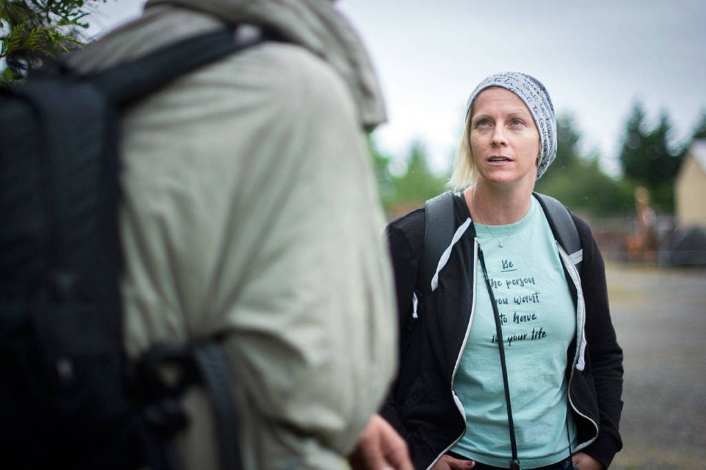 Rediscovery Program Director Amy Miller talks with a man experiencing homelessness who was reported for trespassing. (Jesse Major/for Peninsula Daily News)