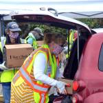 Volunteers Bruce Leigh and Nancy Elwert with Community Emergency Response Teams (CERT) place food boxes in a trunk June 10 at Sequim High School. Free food boxes are available through the USDA from 11 a.m. to 2 p.m. Wednesdays through Aug. 19. (Matthew Nash/Olympic Peninsula News Group)