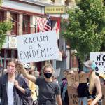Ken Park/Peninsula Daily News Racism is a Pandemic reads the sign carried by a masked participant in Port Townsends Juneteenth rally and march, which drew more than 1,000 people.