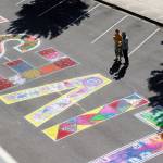 Ken Park/Peninsula Daily News Two people look over the colorful designs in the word Lives in the mural on Water Street in Port Townsend before the march.
