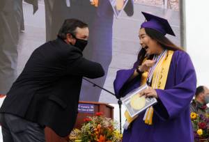 Michael Dashiell /Olympic Peninsula News Group                                After receiving her diploma, class president Erin Dwyer gets an elbow bump from Sequim High School principal Shawn Langston at Fridays SHS commencement ceremony. Sequim Gazette photo by Michael Dashiell