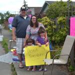 The Hannam family sits outside their downtown Sequim home waving to cars in honor of Noras third birthday Saturday, June 20, 2020. (Matthew Nash/Olympic Peninsula News Group)