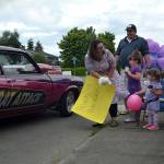 A driver drops off a plush duck for 3-year-old Nora Hannams honk-and-wave birthday party. Her mom, Wynn, sister, Ellie, and dad, Jared, held signs and waved as a family. (Matthew Nash/Olympic Peninsula News Group)