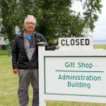 Friends of Fort Worden president Terry LeLievre stands with the sign proclaiming the Fort Worden State Park gift shop closed. The closure has cut into the groups revenues and so it is pursuing other fundraising measures to help it support the park. (Ken Park/Peninsula Daily News)