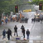 Protesters stand on barricades a block away as Seattle Department of Transportation workers remove other barricades at the intersection of 10th Ave. and Pine St., Tuesday, June 30, 2020 at the CHOP (Capitol Hill Occupied Protest) zone in Seattle. Protesters quickly moved couches, trash cans and other materials in to replace the cleared barricades. The area has been occupied by protesters since Seattle Police pulled back from their East Precinct building following violent clashes with demonstrators earlier in the month. (AP Photo/Ted S. Warren)