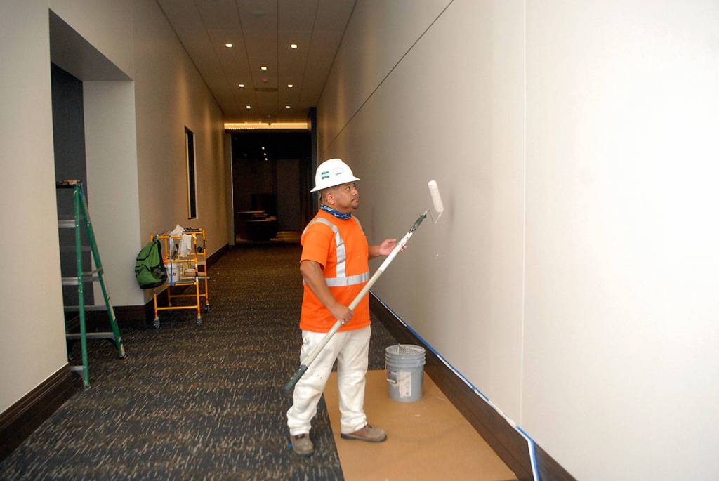 Wilder Pedroza of Spokane-based Custom Painting prepares a ground-floor hallway at the 7 Cedars Hotel on Tuesday. (Keith Thorpe/Peninsula Daily News)