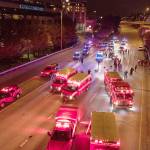 Emergency personnel work at the site where a driver sped through a protest-related closure on the Interstate 5 freeway in Seattle, authorities said early Saturday, July 4. (James Anderson via The Associated Press)