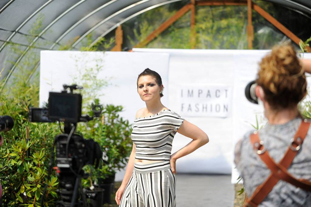 Sarah Shea of Sequim walks the runway to promote sustainable clothing lines through Impact Fashion. Photographers and videographers like Cindy Roth, right, will help compile footage and photos for the Sept. 4 debut of the fashion show as part of a two-day summit. (Matthew Nash/Olympic Peninsula News Group)