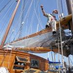 Capt. Nate Seward mouses a shackle Thursday, Aug. 13, 2020, while sitting on a boom of the Schooner Adventuress docked at Port Townsend Boat Haven. (Nicholas Johnson/Peninsula Daily News)
