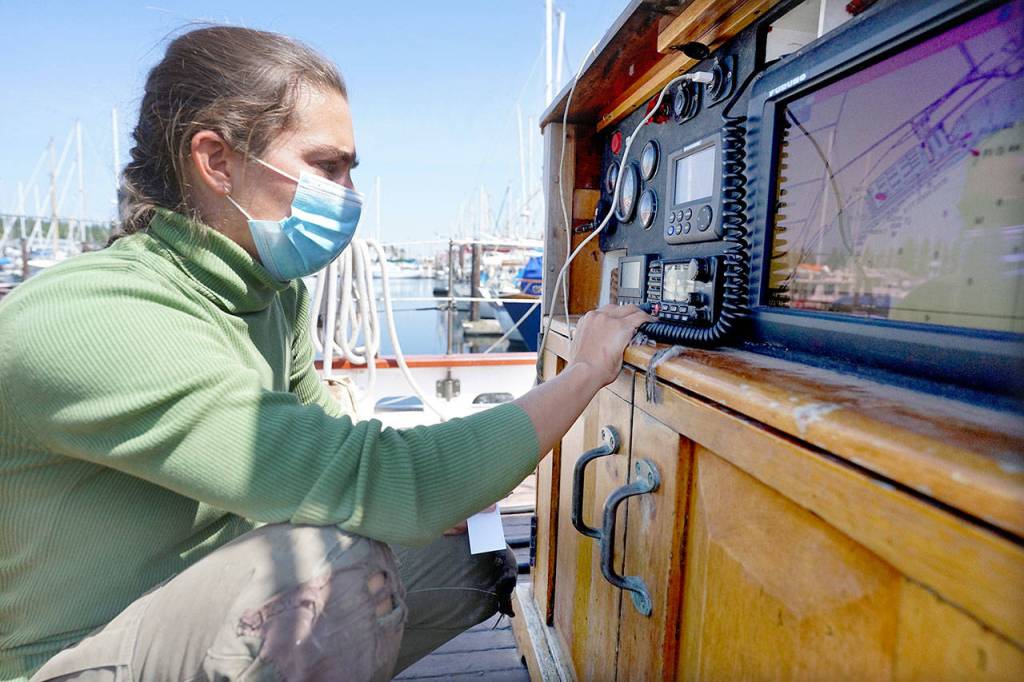 Capt. Katelinn Shaw checks that the Schooner Adventuress radio is programmed with the historic ships information Thursday afternoon while docked at Port Townsend Boat Haven. (Nicholas Johnson/Peninsula Daily News)