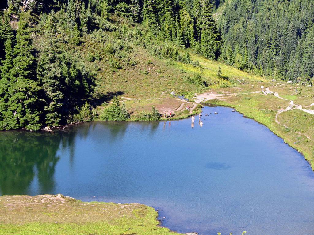 Hikers cool off in Heart Lake on the High Divide/Seven Lakes Basin loop from Sol Duc Falls. (Rob Ollikainen/Peninsula Daily News)