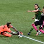 Portland Timbers goalkeeper Steve Clark, left, blocks the shot of Seattle Sounders forward Raul Ruidiaz, right, as Portland Timbers Jorge Villafana, center, defends during the first half of an MLS soccer match in Portland, Ore., Sunday, Aug. 23, 2020. (AP Photo/Steve Dykes)