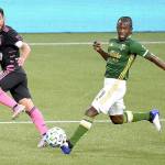 Seattle Sounders midfielder Nicolas Lodeiro, left, passes the ball past Portland Timbers midfielder Diego Chara during the first half of an MLS soccer match in Portland, Ore., on Sunday, Aug. 23, 2020. (Steve Dykes/Associated Press)