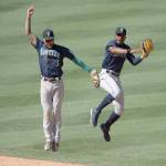Seattle Mariners shortstop J.P. Crawford, left, and center fielder Kyle Lewis celebrate the teams win over the Los Angeles Angels in a Monday baseball game in Anaheim, Calif. (Kyusung Gong/The Associated Press)