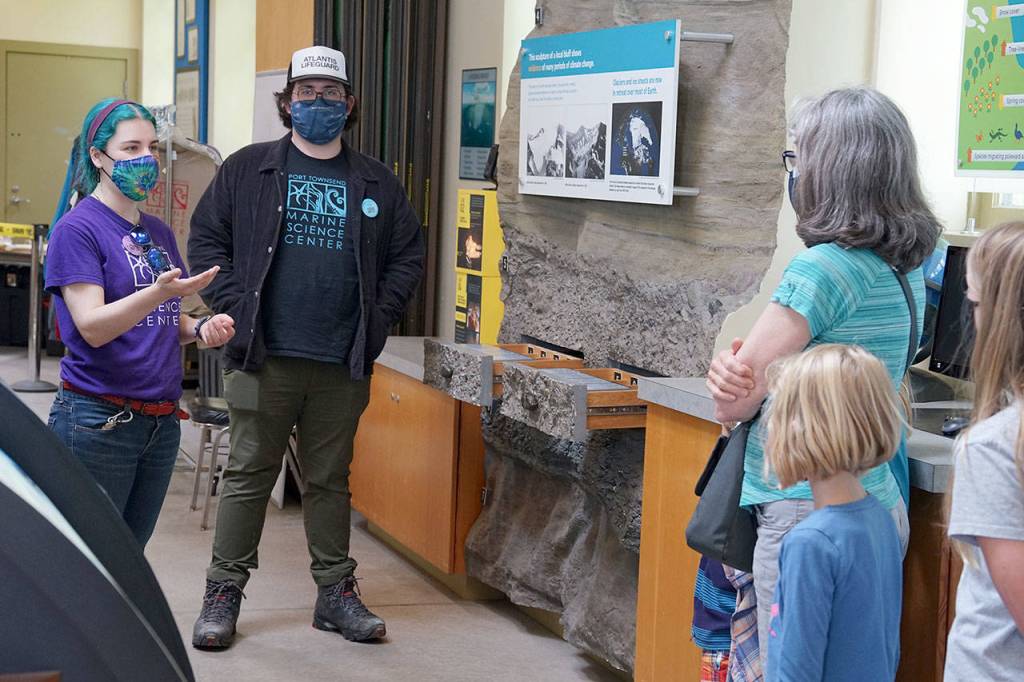 Carolyn Woods, left, education coordinator at the Port Townsend Marine Science Center, leads a family through the science centers museum Friday at Fort Worden State Park. (Nicholas Johnson/Peninsula Daily News)