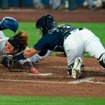 The Texas Rangers Shin-Soo Choo, left, touches home plate to score before Seattle Mariners catcher Luis Torrens, right, can make a tag on a two-run double by Rangers Joey Gallo off Mariners starting pitcher Marco Gonzales during the fourth inning Monday in Seattle. (Stephen Brashear/Associated Press)