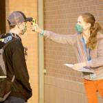 Paraeducator Alice Fraser, right, checks seventh-grader Garret Warrens temperature Tuesday morning outside Blue Heron Middle School in Port Townsend. (Nicholas Johnson/Peninsula Daily News)