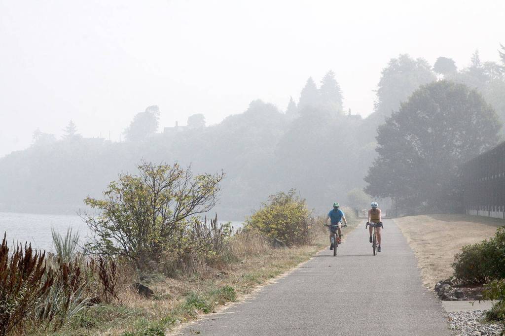 Mike and Mel Vascovski of Seattle bike the Port Angeles Waterfront Trail on Friday. The pair came to Port Angeles hoping to find less smoke. (Dave Logan/For Peninsula Daily News)