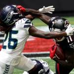Atlanta Falcons wide receiver Julio Jones (11) grabs the facemask of Seattle Seahawks cornerback Shaquill Griffin (26) during the first half Sunday in Atlanta. (John Bazemore/Associated Press)