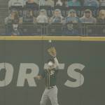 Oakland Athletics right fielder Stephen Piscotty, right, wears a mask as he catches a fly ball hit by Seattle Mariners Kyle Seager as smoke from wildfires fills the air at T-Mobile Park during the first inning of a doubleheader Monday in Seattle. (Ted S. Warren/Associated Press)