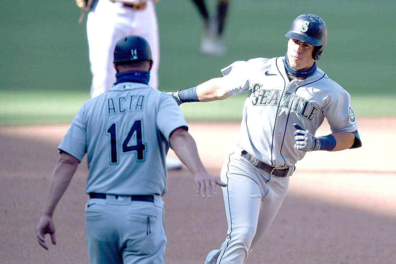 Seattle Mariners Dylan Moore (25) is congratulated by Manny Acta (14) after hitting a two-run home run against the San Diego Padres on Sunday, Sept. 20, 2020, in San Diego. (Denis Poroy/Associated Press)