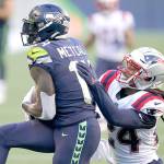 Seattle Seahawks wide receiver DK Metcalf, left, catches a pass for a touchdown as New England Patriots cornerback Stephon Gilmore defends Sunday in Seattle. (Elaine Thompson/Associated Press)