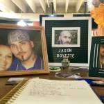 Framed photos and an urn filled with ashes are displayed inside The Tin Brick during a wake for chef Jason Boyette on Sept. 21 in downtown Port Townsend. At left is Boyette with his partner of 16 years, Amanda Timentwa, and at right is Boyette with his son Elias, 5. (Nicholas Johnson/Peninsula Daily News)