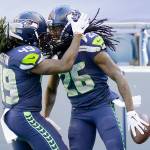 Seattle Seahawks cornerback Shaquill Griffin (26) is greeted by his twin brother, outside linebacker Shaquem Griffin (49) after Shaquill Griffin intercepted a pass against the Dallas Cowboys during the first half of an NFL football game Sunday, Sept. 27, 2020, in Seattle. (Elaine Thompson/Associated Press)