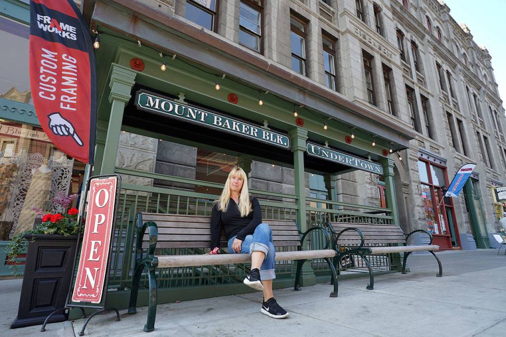 Port Townsend restaurateur Kris Nelson sits in front of the Mount Baker Block Buildings underground entryway on Taylor Street on Friday afternoon in downtown Port Townsend. (Nicholas Johnson/Peninsula Daily News)