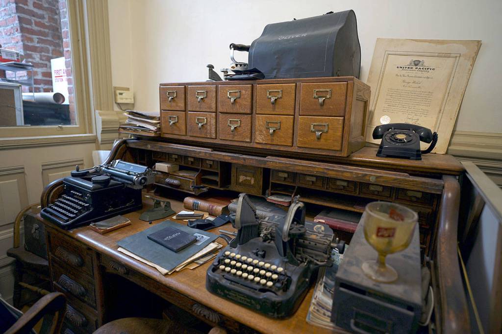 Old typewriters and other historical artifacts sit atop a desk once used by former Jefferson County Prosecuting Attorney William J. Daly, who for decades rented office space on the second floor of the Mount Baker Block Building in downtown Port Townsend. (Nicholas Johnson/Peninsula Daily News)