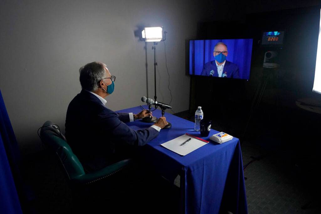 Washington Gov. Jay Inslee, a Democrat, takes part in a sound check in the room he will be in for his debate with Republican Loren Culp, Wednesday, Oct. 7, 2020, in Olympia, Wash. Due to concerns over COVID-19, each candidate will be taking part in the debate from individual rooms separate from moderators. (Ted S. Warren/Associated Press)