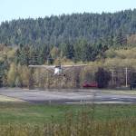 A plane flies over the Jefferson County International Airport's 3,000-foot runway outside Port Townsend on Wednesday afternoon. The Port of Port Townsend plans to close the runway from 7:30 a.m. Monday until 5 p.m. Oct. 23 so it can be resurfaced. That work, intended to correct deficiencies in the pavement, was originally planned for late September but was delayed due to rainy weather. (Nicholas Johnson/Peninsula Daily News)
