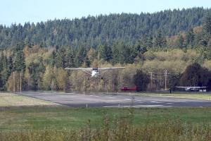 A plane flies over the Jefferson County International Airport's 3,000-foot runway outside Port Townsend on Wednesday afternoon. The Port of Port Townsend plans to close the runway from 7:30 a.m. Monday until 5 p.m. Oct. 23 so it can be resurfaced. That work, intended to correct deficiencies in the pavement, was originally planned for late September but was delayed due to rainy weather. (Nicholas Johnson/Peninsula Daily News)