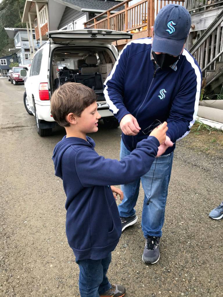 Jefferson County first-grader Henry Norris is fitted with a microphone by a Seattle Kraken video production staffer before filming scenes in a video announcing Norris as the winner of a lifetime pass on the Washington State Ferry system. (Katy Norris)