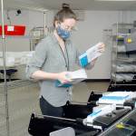 Clallam County election worker Nicole Mischke pulls sorted ballots from a sorting machine Wednesday, Oct. 21, 2020, at the county courthouse in Port Angeles. (Keith Thorpe/Peninsula Daily News)