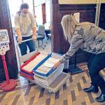 Barb Ferguson, left, and Brenda Huntingford, both employees with the Jefferson County Auditors Office, transfer trays of ballots to a room for opening and hands-on review after their signatures were checked against a state database Tuesday, Oct. 27, 2020, at the Jefferson County Courthouse in Port Townsend. (Nicholas Johnson/Peninsula Daily News)