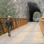 Keith Thorpe/Peninsula Daily News
Olympic National Park Superintendent Sarah Creachbaum walks across a new bridge on the Spruce Railroad Trail abutting the recently renovated Daley-Rankin Tunnel at the start of a ceremony on Thursday to celebrate the soon-to-be-open trail on the north shore of Lake Crescent.