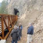 Dedication ceremony guests examine the underside of a new bridge on the Spruce Railroad Trail on Thursday. (Keith Thorpe/Peninsula Daily News)